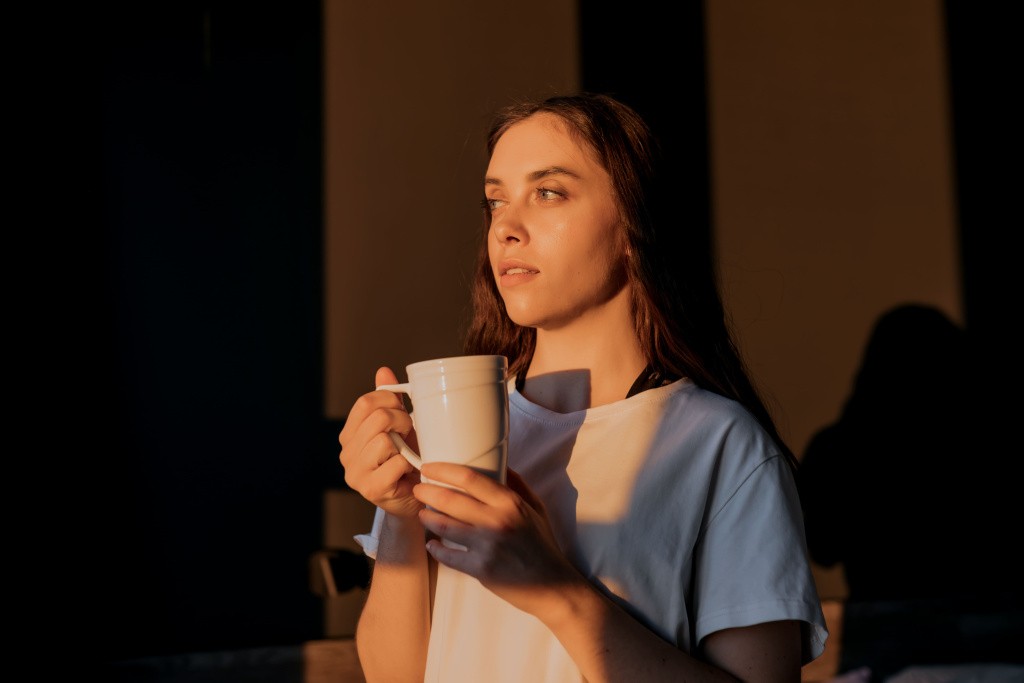 veselaa-devuska-s-krasivymi-glazami-v-beloi-futbolke-stoit-na-temnom-fone-s-caskoi-caa-na-solnce-vdohnovlennaa-satenka-smotrit-v-okno-koncepcia-scast-a (1).jpg